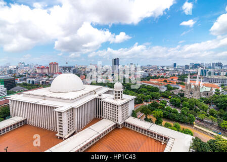 Jakarta, Indonesia. 16th of February 2017. The main building of Istiqlal Mosque in Jakarta, Indonesia. The Jakarta Cathedral lies across the river. Dozens of members of the outdoor activity enthusiasts clubs, rope access companies, and outdoor adventure service organization, gather voluntarily to clean up the largest mosque in Southeast Asia as a symbol of unity and tolerance. Stock Photo