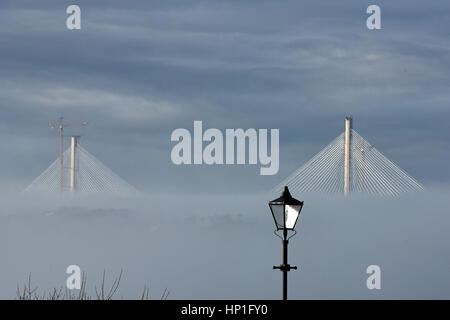 Inverkeithing, Scotland, UK. 17th February, 2017. The towers of the new Queensferry Crossing bridge across the Forth Estuary rise out of the morning mist, viewed from the seafront at St David's Harbour, Dalgety Bay, Credit: Ken Jack/Alamy Live News Stock Photo