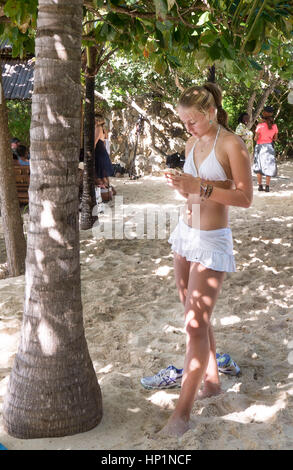 Neckar Island, Caribbean, British Virgin Islands. 17th Nov, 2014. Tennis player Olivia Elliott from the UK checks her phone after a lunch. Elliott beat all other under 14 players in a Necker Cup tournament held in the UK to get the chance to play on Necker. Credit: Mark Greenberg/ZUMA Wire/Alamy Live News Stock Photo