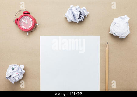 Business concept:red clock,white blank paper,crumpled paper and pencil on brown paper background Stock Photo