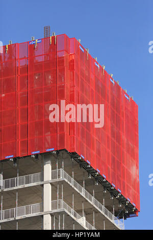Climbing, protective screens surround the top of a new, concrete framed tower block under construction in Salford Quays, Manchester, UK Stock Photo