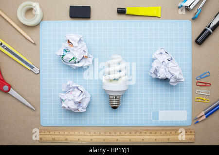 concept:stapler,glue,scissor,cutter,tape,pen,pencil,clip,ruler,rubber, cutting mat ,lamp,crumpled paper and color pencil on brown paper background.Top Stock Photo