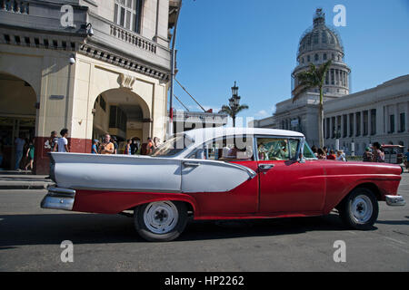 Classic 1950's American car drives past the Capitol Nacional in Havana Cuba Stock Photo