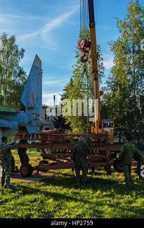 The jet fighter SU-27 is set by a monument in the territory of the Vitebsk aeroclub. Assembly of the SU-27 plane - installation of wings. Stock Photo