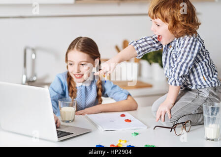 Excited kids studying enthusiastically using technologies Stock Photo