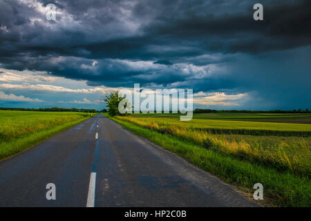 Stormy clouds over asphalt road Stock Photo