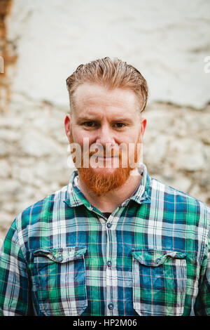 Portrait of red haired man with plaid shirt and long beard Stock Photo