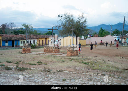 A group of young Cuban boys playing football on rough ground football pitch in Trinidad Cuba Stock Photo