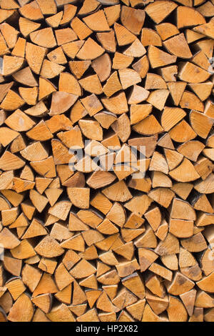 firewood - seasoned kiln-dried split logs neatly stacked background Stock Photo