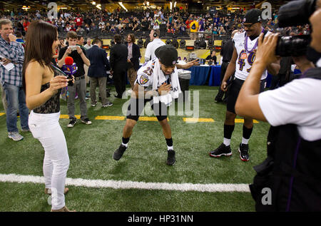 Johanna Pena Gutierrez a reporter with TV Azteca Noreste, left, dances with Baltimore Ravens' Asa Jackson, center, and D.J. Bryant at the Super Bowl XLVII Media Day on January 29, 2013, in New Orleans, Louisiana. Photo by Francis Specker Stock Photo