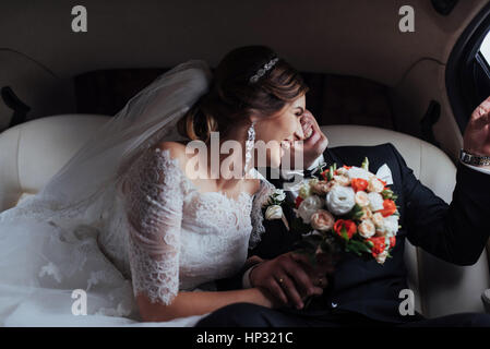 young couple in a car in wedding day.