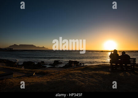 Cape Town, South Africa - November 15, 2016: Unidentified seniors couple are enjoying the colorful sunset on the beach at Bloubergstrand in South Afri Stock Photo