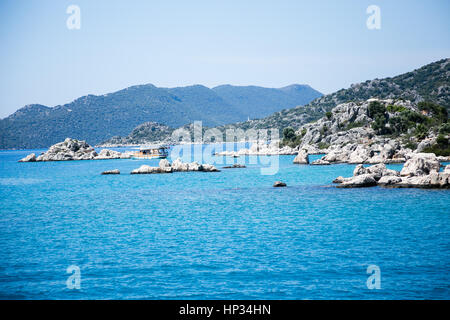 Seascape of islands and mountains around sunken city of Kekova in Uchagiz Antalya in Turkey with one small touristic boat Stock Photo