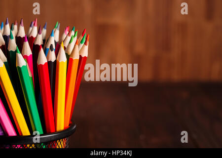 different pencils on the brown wooden table background. Colorful pencils. School and education. Drawing and painting. NAtural materials. Brown backgro Stock Photo
