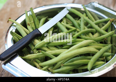 Green beans and knife in silver metal bowl Stock Photo