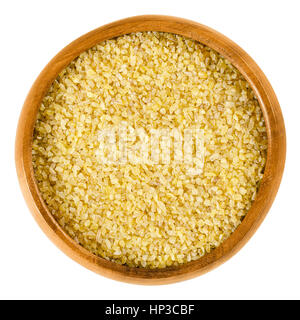 Bulgur in wooden bowl. Uncooked cereal food, most often made from groats of durum wheat. Also called burghul, a kind of dried cracked wheat. Stock Photo