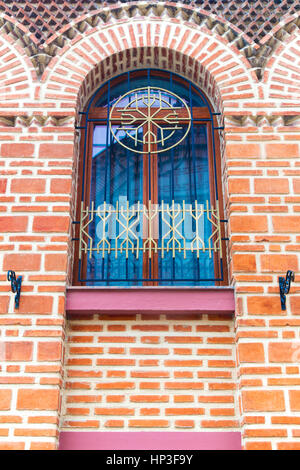 Window with decorative metal grid on stylish brick wall Stock Photo