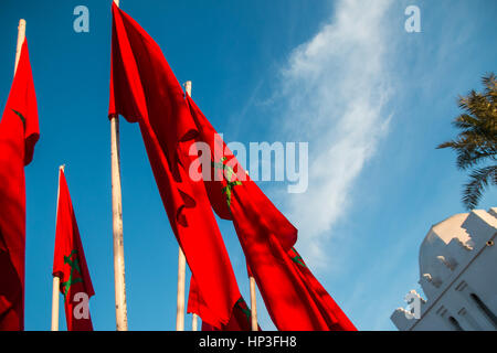 Moroccan flags in Marrakech on a background of blue sky wide shot Stock Photo