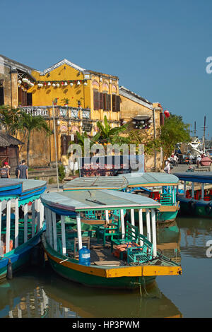 Tourist boats on Thu Bon River and historic buildings, Hoi An (UNESCO World Heritage Site), Vietnam Stock Photo