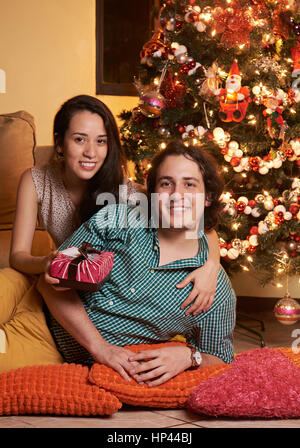 happy married couple in christmas evening with present box Stock Photo
