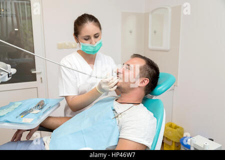 Image of dentist treating the patient's dental caries, in the Dental Clinic Stock Photo