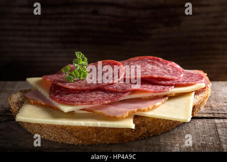 Open sandwich made from cheese, ham and Italian salami on wooden background Stock Photo