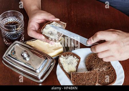 man buttered bread knife. he is left-handed. left hand, male hand. soup, bread, butter knife Stock Photo