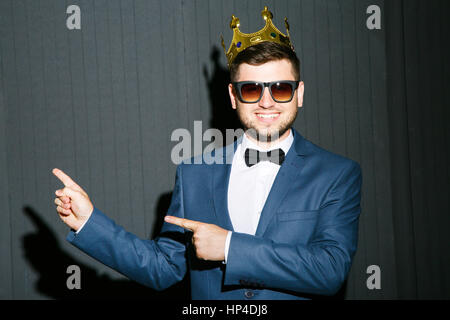 Man in crown pointing aside Stock Photo