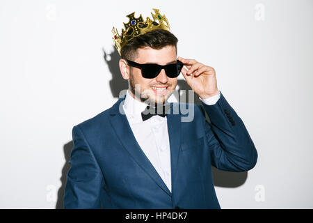 Man in crown touching glasses Stock Photo