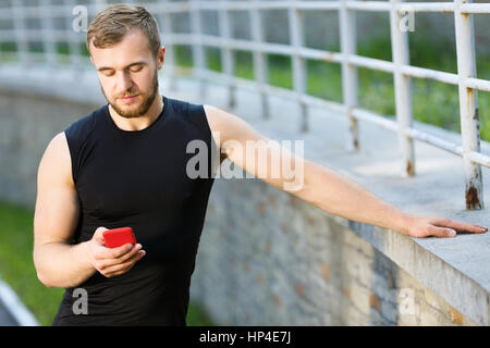Man standing with red mobile phone Stock Photo