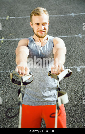 Handsome man doing exercises at stadium  Stock Photo