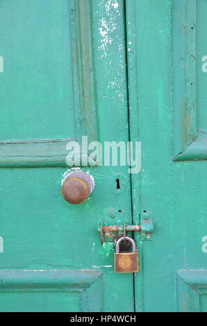 Old secure padlocked green door Stock Photo