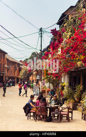 Visitors enjoy a meal at a cafe. Shops, cafes, and traditional Newari architecture in Bandipur Bazaar, Nepal Stock Photo