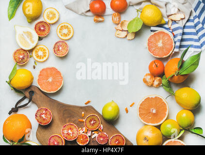 Natural fresh citrus fruits on wooden rustic board over grey marble table background, top view, copy space Stock Photo