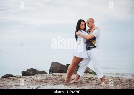 Beautiful inflammatory couple dancing on the beach Stock Photo