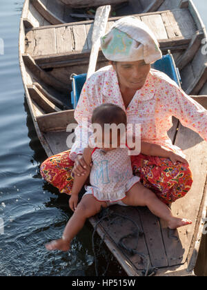 Cambodian woman and child on a boat in Tonle Sap lake Stock Photo