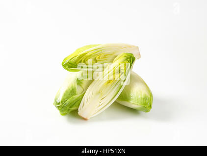 whole and halved heads of fresh belgian endive Stock Photo