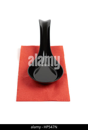 Black plastic spoon on red paper napkin isolated on white background Stock Photo