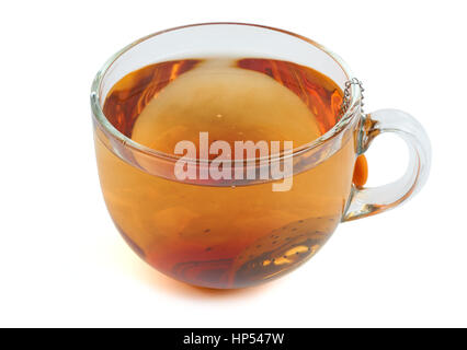 Brewing black tea in the transparent glass cup with tea strainer. Isolated on white Stock Photo
