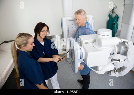 Patient Looking At Radiologists Using Digital Tablet In Hospital Stock Photo