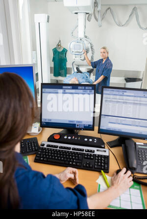 Doctor Taking Patient's Xray While Coworker Using Computer At De Stock Photo