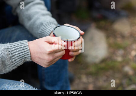 Man Holding Coffee Cup At Campsite Stock Photo