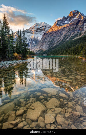 Mount Edith Cavell reflected in the calm river at sunrise in the rocky mountains of Jasper National Park, Alberta, Canada Stock Photo