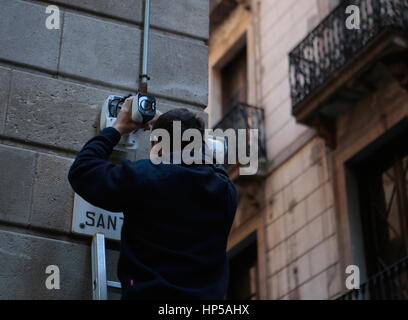 a man installs a surveillance camera in a corner in the city of barcelona Stock Photo