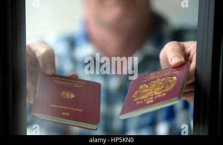 Berlin, Germany. 06th July, 2016. A man holds up a British (R) and a German passport in Berlin, Germany, 06 July 2016. Photo: Britta Pedersen/dpa | usage worldwide/dpa/Alamy Live News Stock Photo