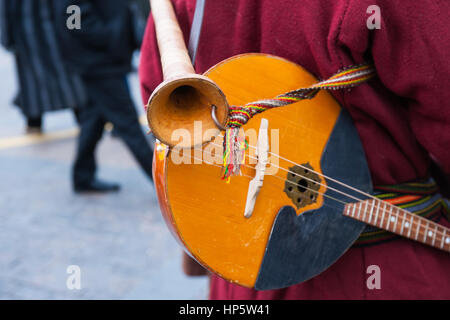 Moscow, Russia. Sunday, Feb. 19, 2017. Vintage folk musical string and wind instruments hang on the back of an unidentified, unrecognizable artist. Maslenitsa, pancake, cheese fare week festival, carnival started in the city. People enjoy street performances and eat hot pancakes. This is also farewell to winter festival. The day is warm (+2C, about 36F) but gloomy. © Alex's Pictures/Alamy Live News Stock Photo