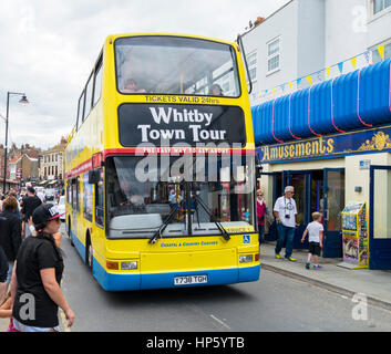 A Whitby Town Tour coach passing through a busy seafront street , North Yorkshire, UK Stock Photo