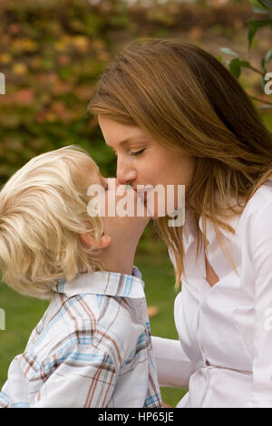 Happy mother hugging her son outside. Stock Photo