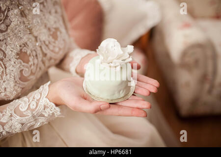 The bride holds a beautiful cake in hands Stock Photo