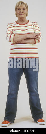 Seniorin in Jeans und Pulli, verschraenkte Arme (model-released)